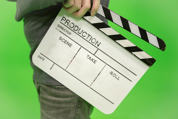 Video producer man holding movie clapper board on green background