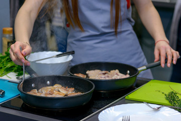 Woman hands cooked in a two frying pan