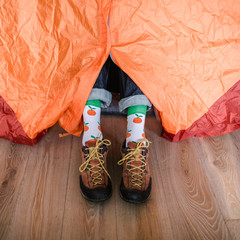 Feet in happy socks. Man is relaxing near tent and warming up his feet in happy socks. - 182762829