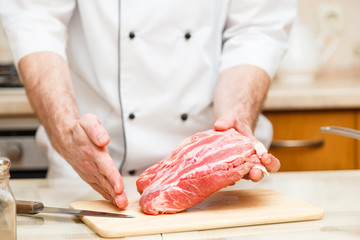 Cook men show how cuts a piece of meat. Close up