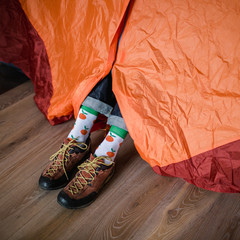 Feet in happy socks. Man is relaxing near tent and warming up his feet in happy socks. - 182763051