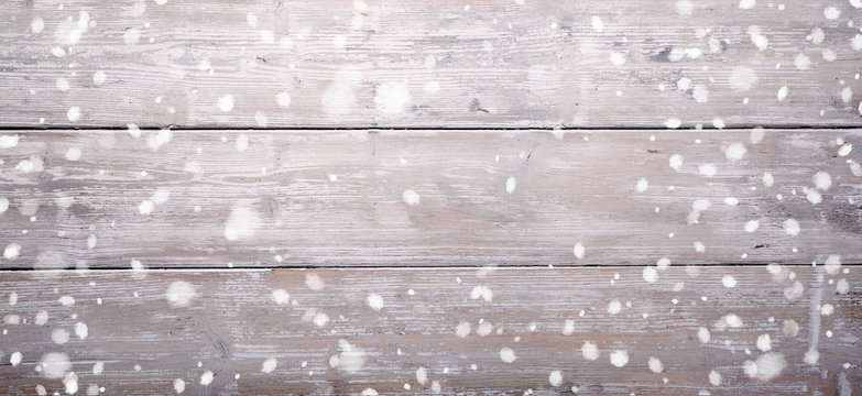 Winter background - Old grey rustic wood and falling snow 