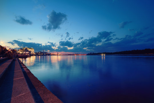 Havana bridge in Kiev at night with colorful illumination, beautiful clouds and reflection in Dnieper river. Wide angle