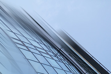 Abstract business modern city urban futuristic architecture background. Real estate concept, motion blur, reflection in glass of high rise skyscraper facade, toned blue picture with bokeh