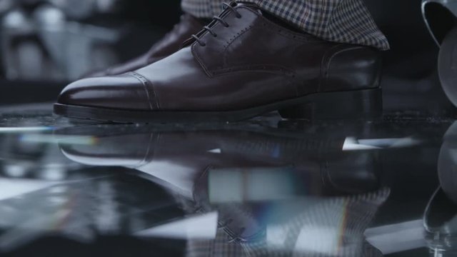 Elegant male brown classic shoes with box on mirror surface. Man in business suit and stylish classy boots.