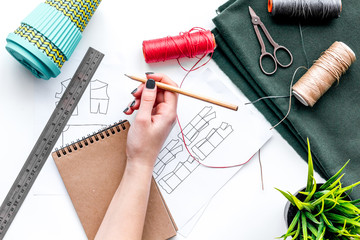 Clothing designer hands' draw the pattern. White background top view