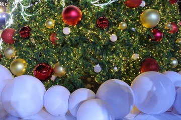 A bright white red-and-gold-colored ball decorates the Christmas tree. Celebrate Christmas and welcome New Year. Happy Holidays