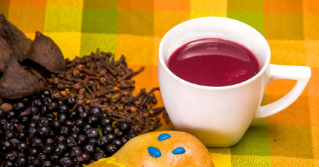 Close up of traditional Ecuadorian dish, colada morada and guaguas de pan, with assorted species to prepare, over a colorful fabrics