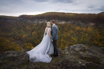 Beautiful couple in the mountains of the wedding in autumn groom and bride