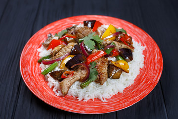 Tasty spicy stir-fry pork meat with rice and roasted vegetables, close up. Delicious food, Pan-Asian, oriental cuisine