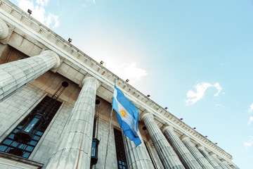 Classic building with columns and Argentine flag flaming