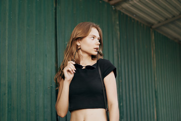 girl posing against the green fence