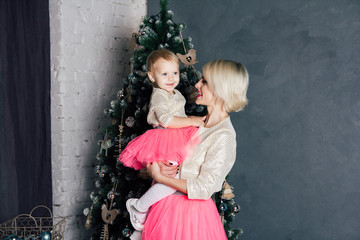 Mother and little daughter posing in the new year interior