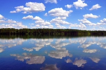 Beautiful reflective cloudy sky in the water of lake in summer day