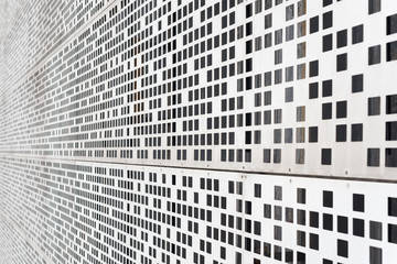 Vanishing point of view of a grey metallic stucture with square holes