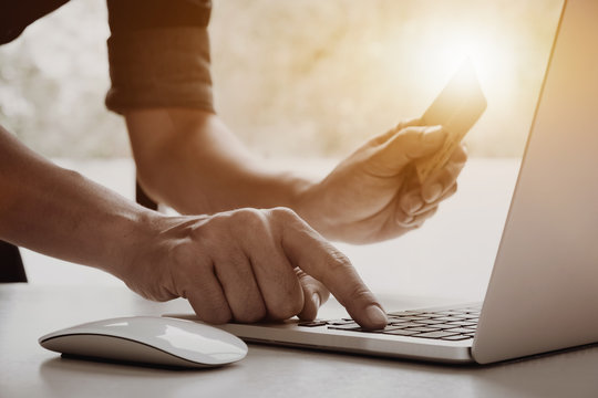 Online payment, Closeup image of man's hands holding a credit card and using laptop computer for online shopping with vintage filter tone