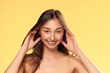 Fototapeta premium cheerful girl on yellow background with developing hair