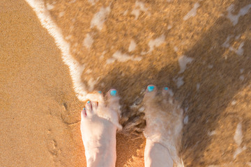 toes in the sand, with water