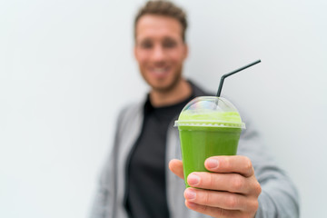 Health man drinking weight loss green smoothie drink. Hand holding plastic cup of vegetable juice, healthy food diet eating lifestyle.