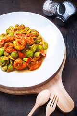 Thai food on white plate and wooden table, Spicy stir-fried shrimp with bitter or twisted cluster or stink bean ( sataw ) and shrimp paste