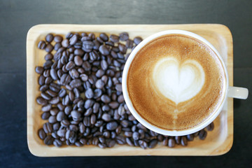 Top view of hot latte coffee with heart shape latte art and coffee beans
