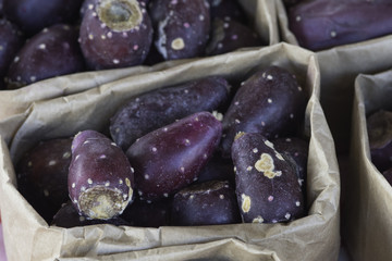 close of brown paper bags filled with prickly pear fruit