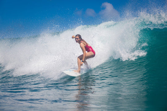 Indonesia, Bali, July 23 2016: A Female Surfer, Leonor Fragoso Riding Big Blue Ocean Surfing Wave, Shot From Water Level