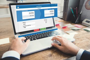 Businessman transferring money with internet online e-banking on laptop computer