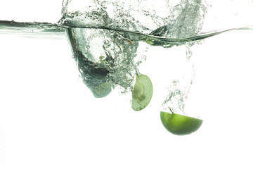 Fresh apples falling into water with splashes