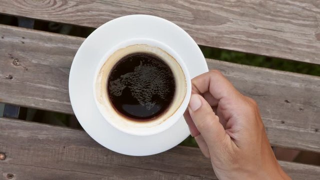 Young Man Taking Cup of Hot Americano Coffee from Wooden Table in Cafe View From Above. 4K Slow Motion Close Up.