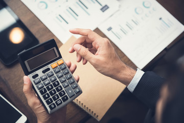 Businessman or financial adviser using calculator calculating and analyzing data