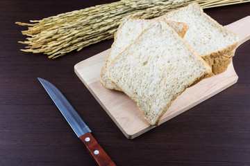 Sliced Whole wheat bread on Chopping Wood and hand knitted background