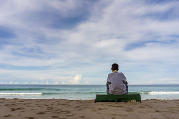 Naklejka premium Lonely boy sitting look at the beautiful sea.