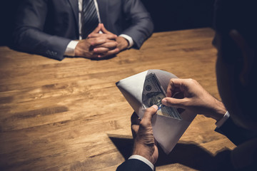 Fototapeta premium Businessman checking money, US dollars, in the envelope just given by his partner