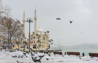 Snowy day in Ortakoy, Istanbul, Turkey. View of Ortakoy Mosque and Bosphorus Bridge.