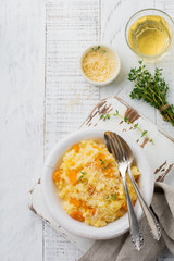 Pumpkin risotto with thyme, garlic, parmesan cheese and white wine on light wooden background. Selective focus. Rustic style. Top view.