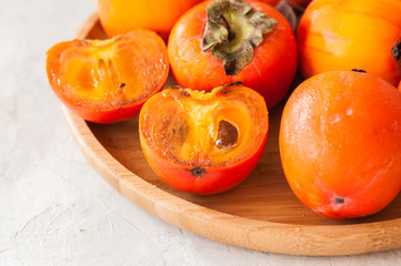 Plate of fresh and ripe persimmons. Close up.