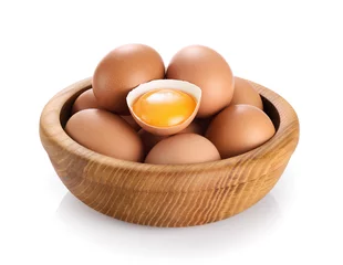 Tuinposter Wooden bowl with eggs isolated on white background. Broken egg, yolk. © vitals