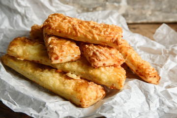 salty sticks in paper bag on rustic wooden background. 