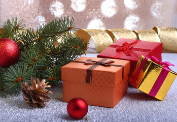 Christmas decoration with gift boxes, colorful christmas balls, christmas tree and cones on a blurry, sparkling and fabulous background.