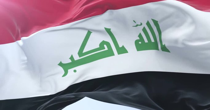 Flag of Iraq waving at wind in slow in blue sky, loop