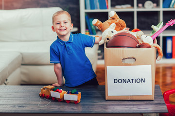 Boy taking donation box full with stuff for donate