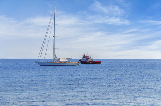 Two docked boat on the horizon of blue peaceful sea with cloudy sky