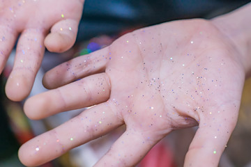 child's hands in glitter