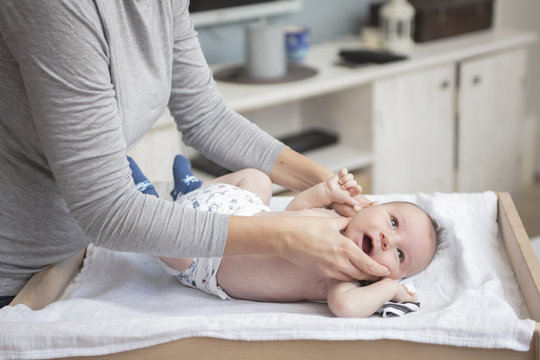 Mother happily playing with her baby after having bathed