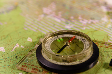 Fototapeta na wymiar Magnetic compass lying on topographical map