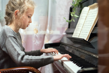 Little girl learning to play the piano. © M-Production