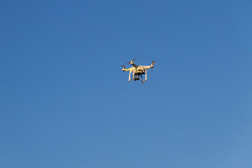 Drone with the camera hovering in blue sky