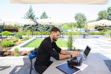 Happy businessman works outside with laptop and enjoying with vi © sisterspro