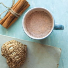 square top view cocoa cup old book cinnamon sticks and knitted heart